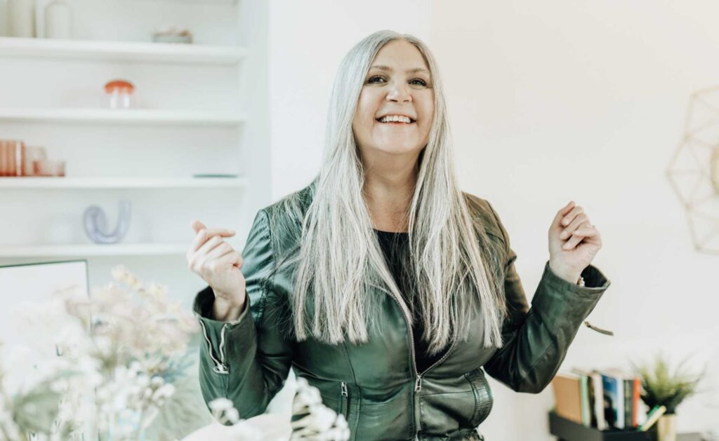 Jasminka Hepperle stahlend und lächelnd in einer grünen Lederjacke